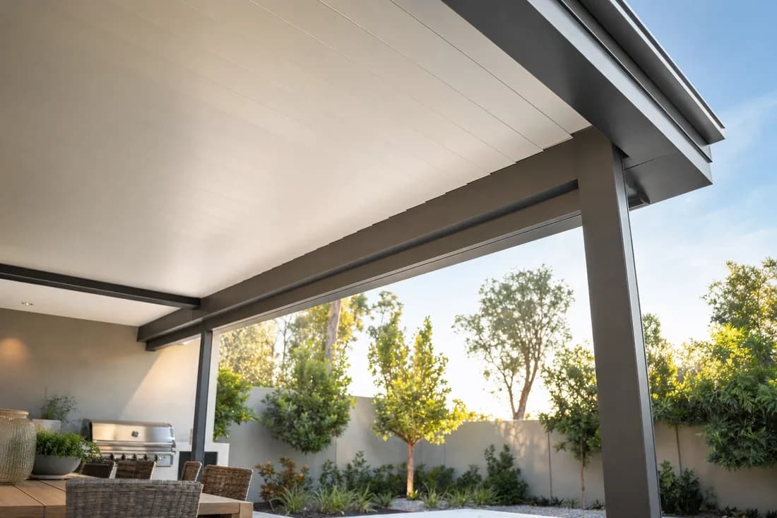 Underside of an insulated Colorbond patio roof showing the flush ceiling panels and slim charcoal steel beam